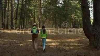 带着孩子的年轻家庭走在森林的小路上